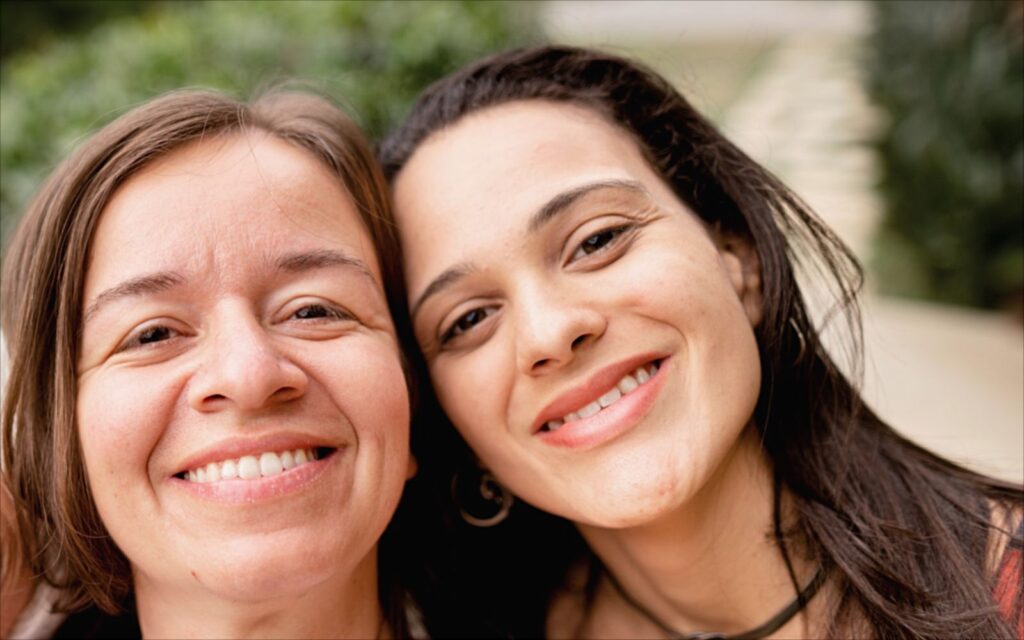 Zwei junge Frauen lachen gemeinsam in die Kamera
